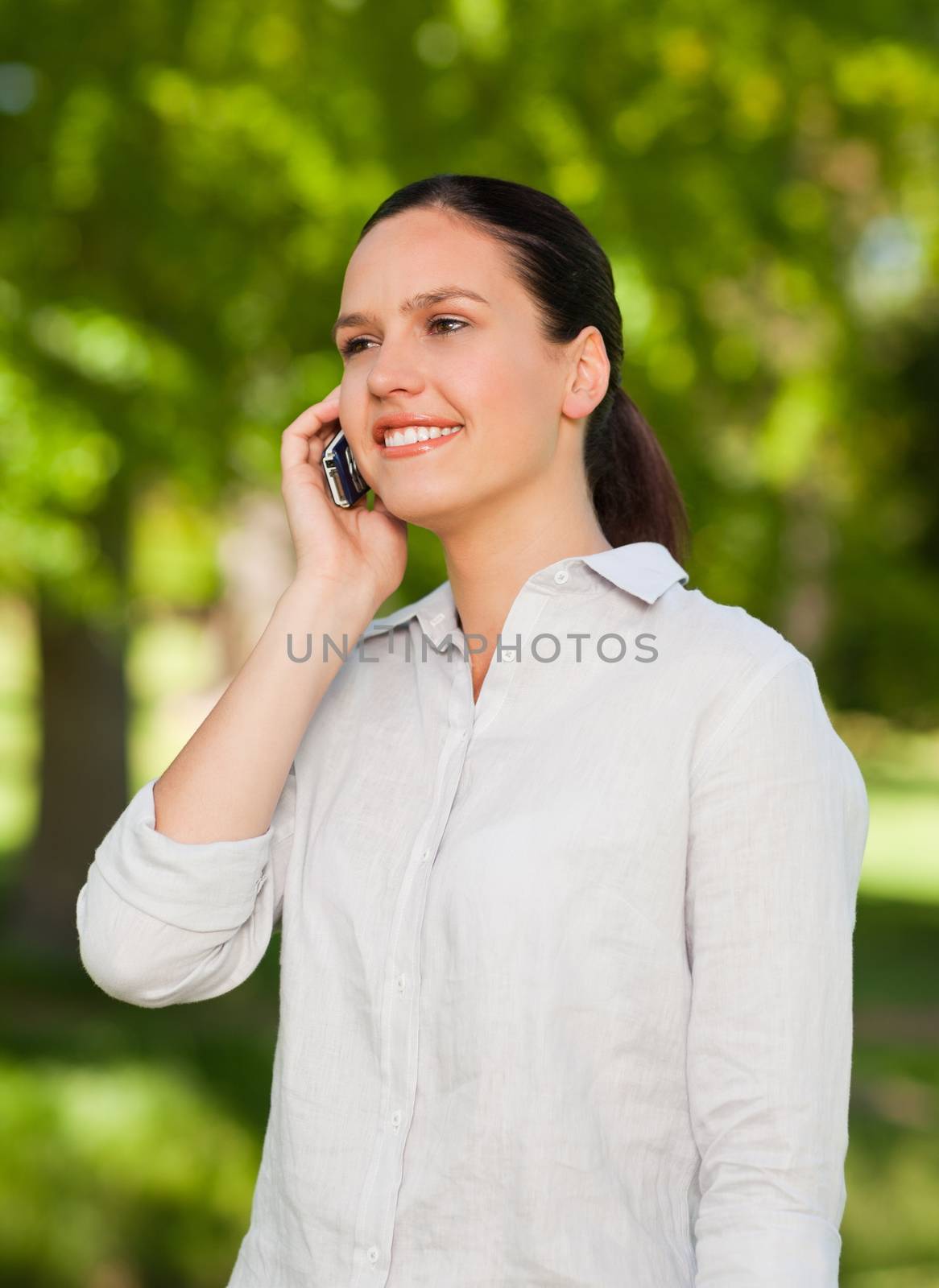 Woman phoning in the park during the summer