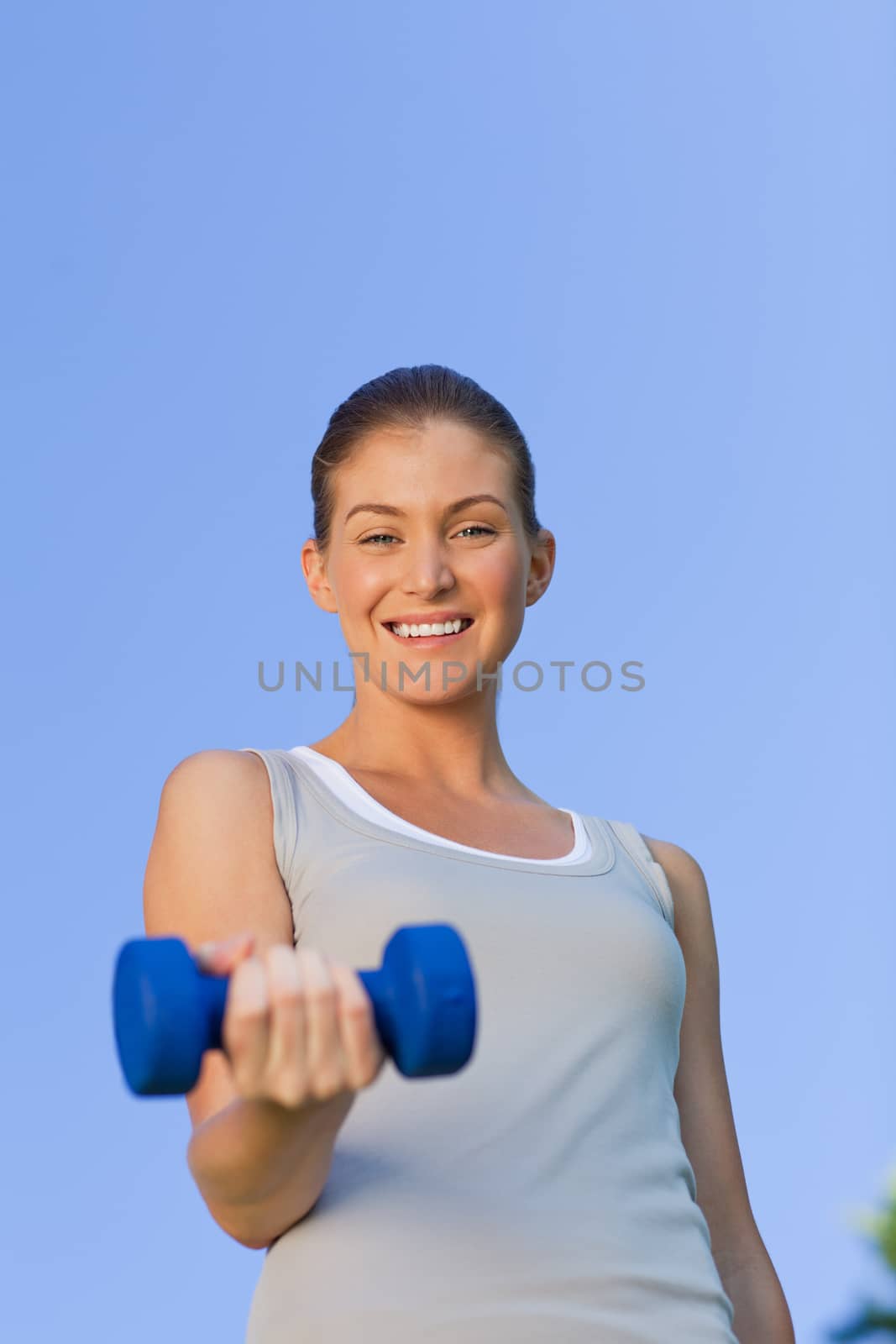 Young woman doing her exercises in the park during the summer