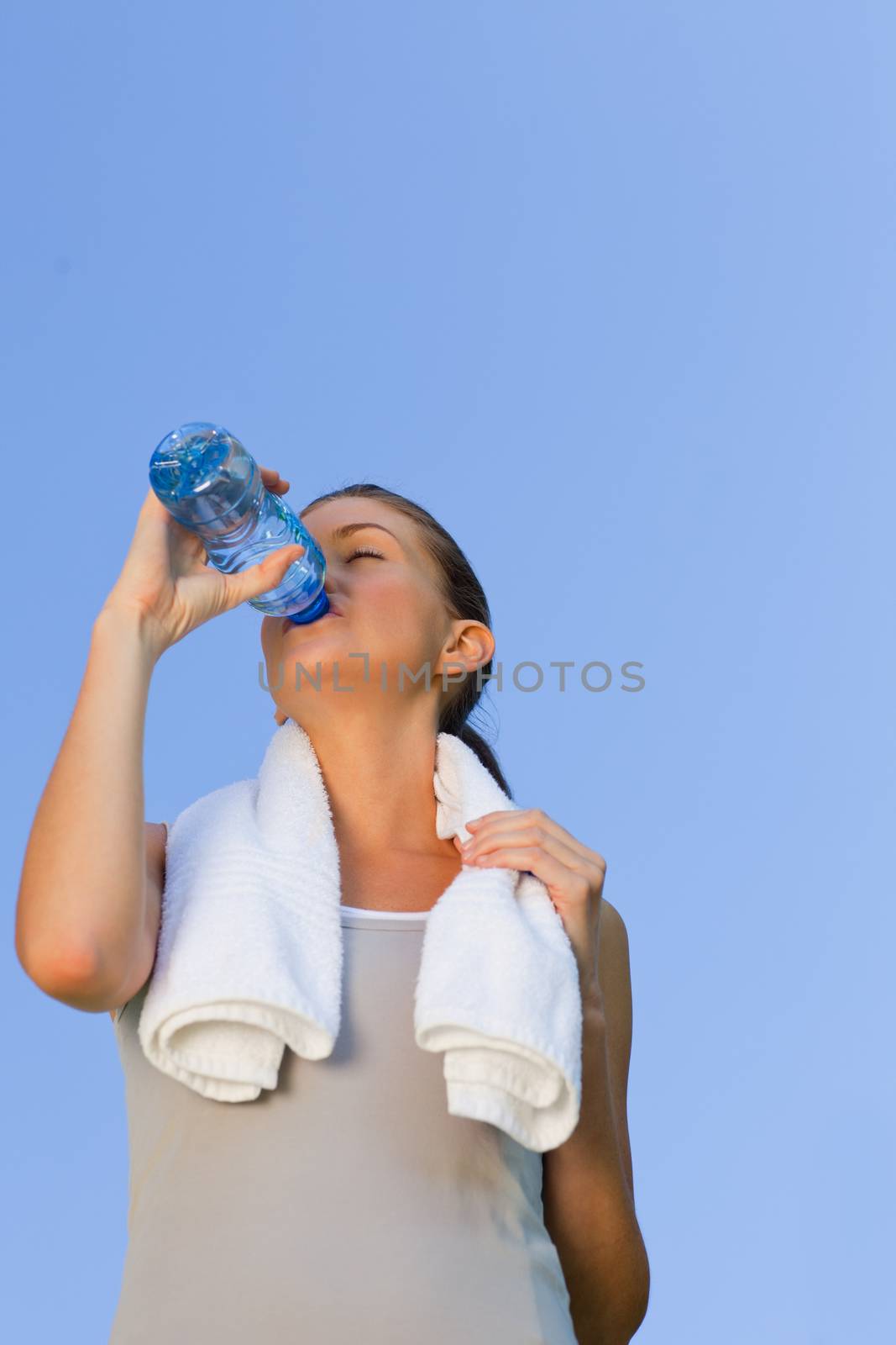Young woman drinking water during the summer