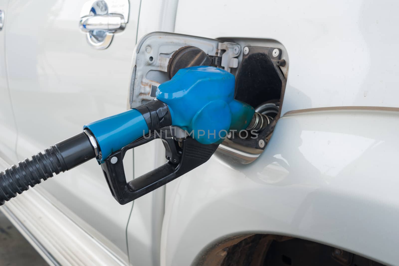 Blue Fuel nozzle to release fuel into car at gas station