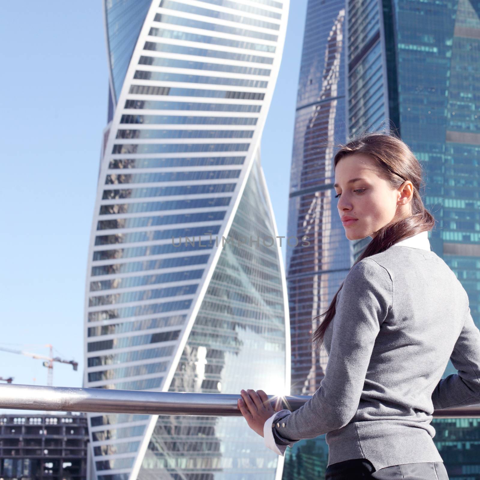 Young beautiful businesswoman outdoors at skyscraper background