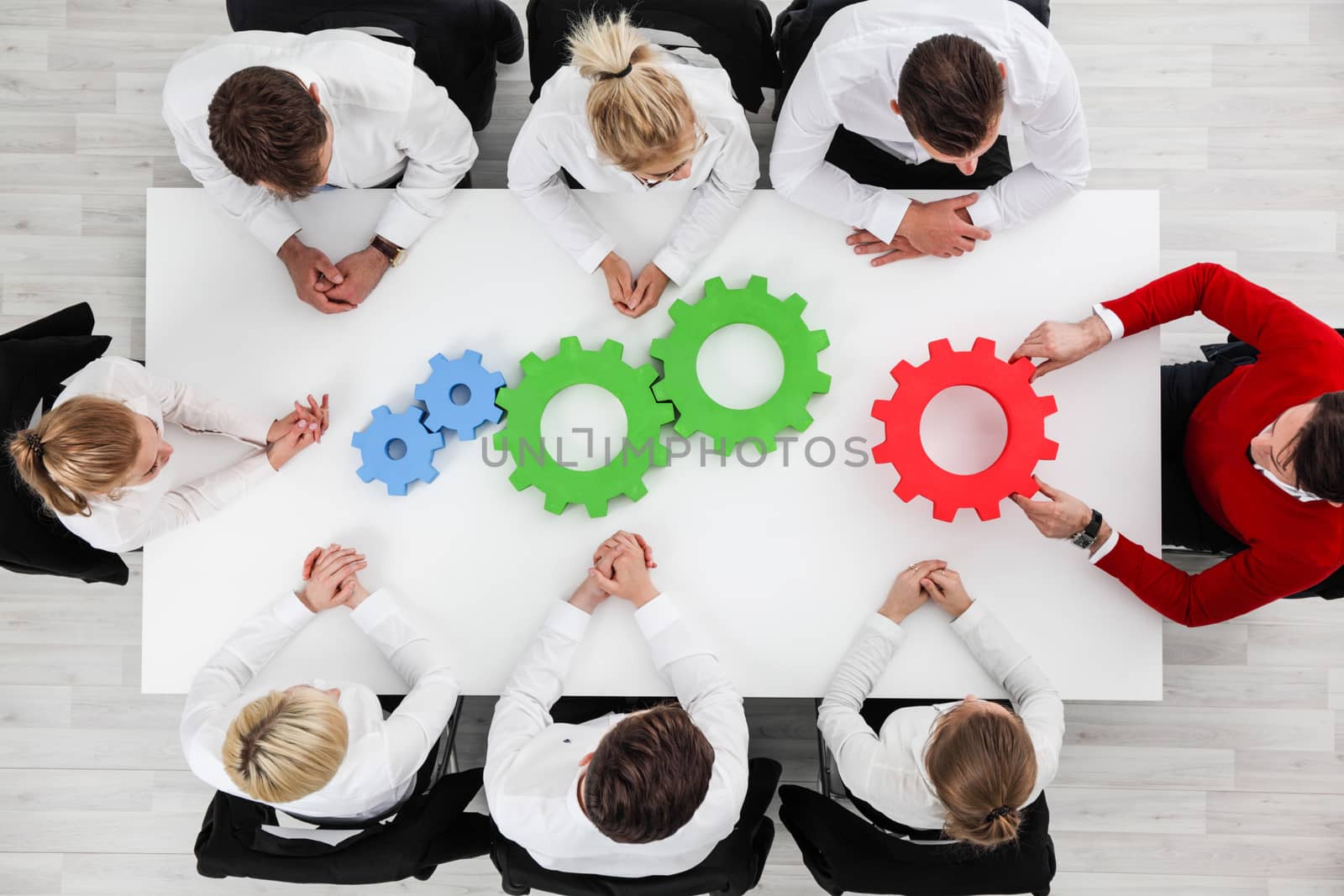 Business problem solution, mechanism of business, teamwork concept, business team sitting around white table with cogs