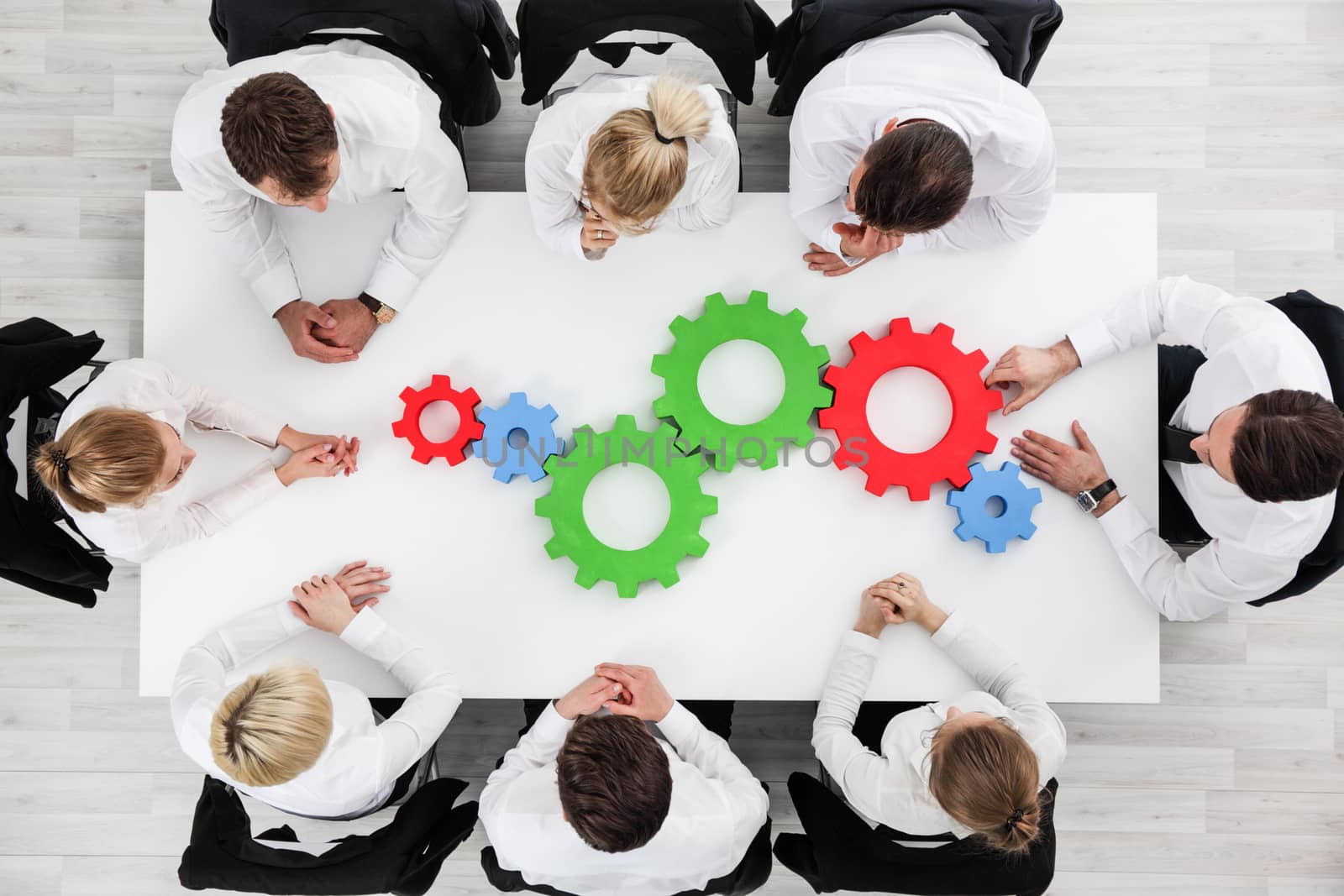 Business problem solution, mechanism of business, teamwork concept, business team sitting around white table with cogs