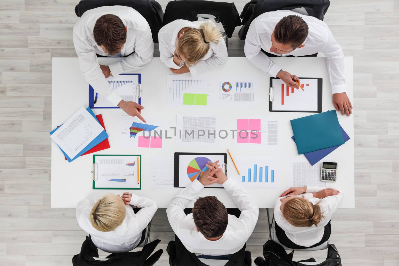 Business people work with statistics documents with tables and diagrams sitting around the table