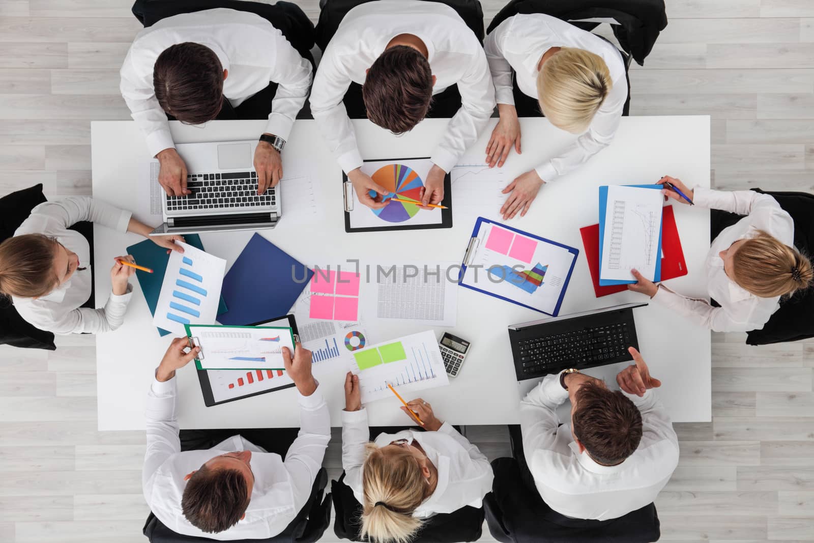 Business people work with statistics documents with tables and diagrams sitting around the table