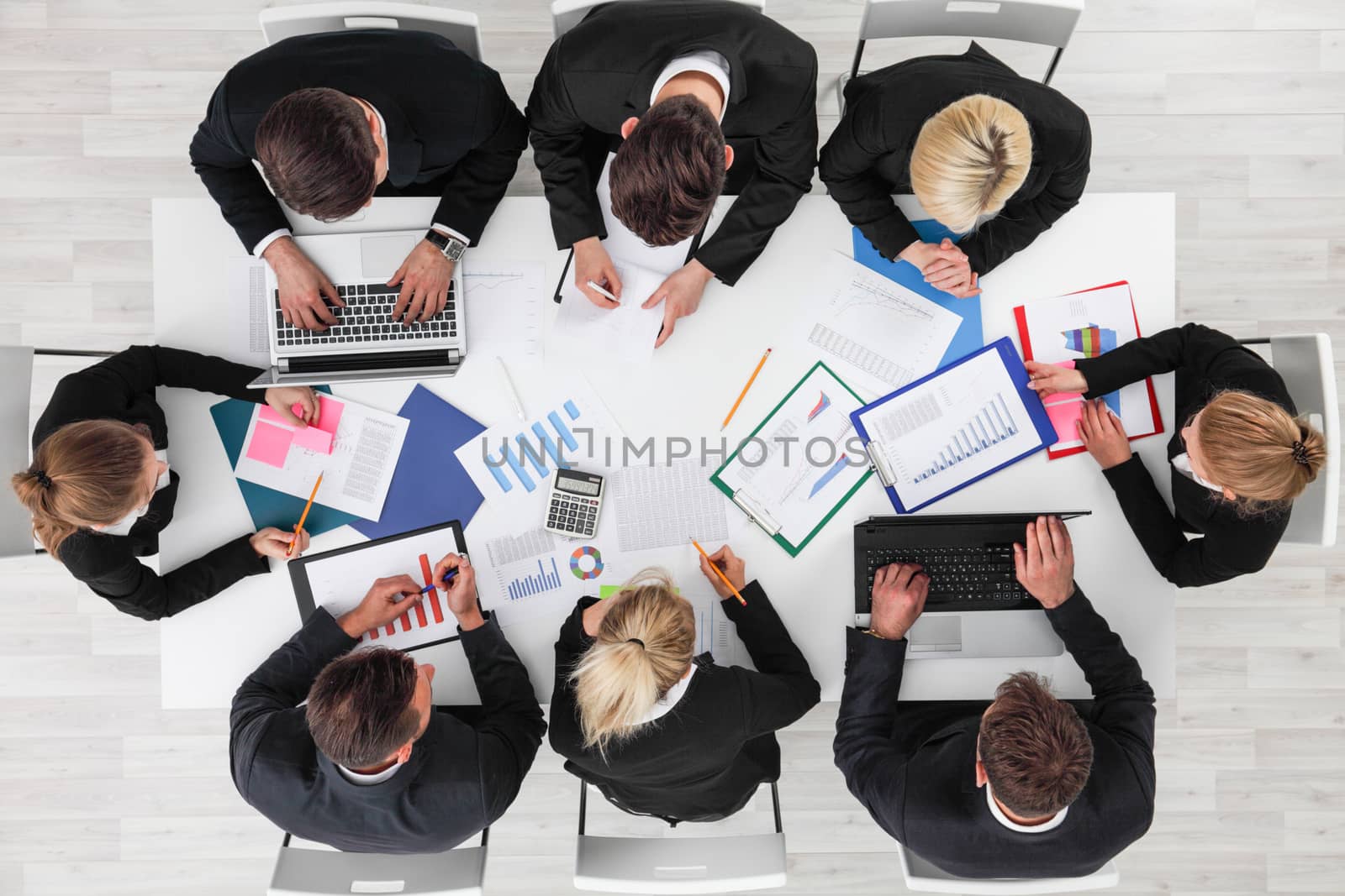 Business people work with statistics documents with tables and diagrams sitting around the table