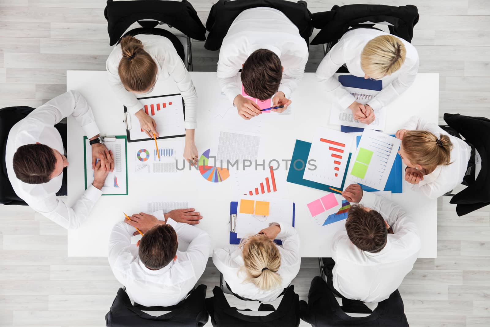 Business people work with statistics documents with tables and diagrams sitting around the table