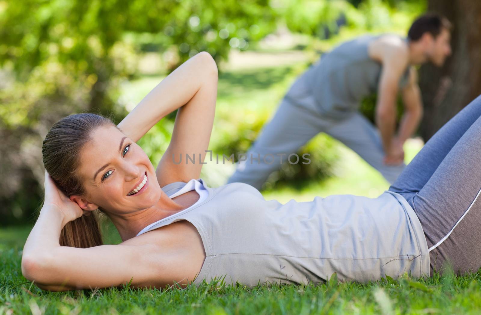 Couple doing their stretches in the park during the summer