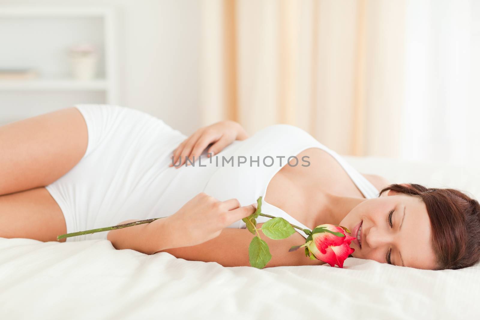 Young Woman with a rose in her bedroom