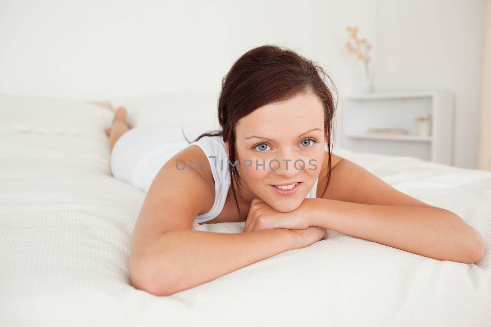 Smiling woman looking at the camera in her bedroom