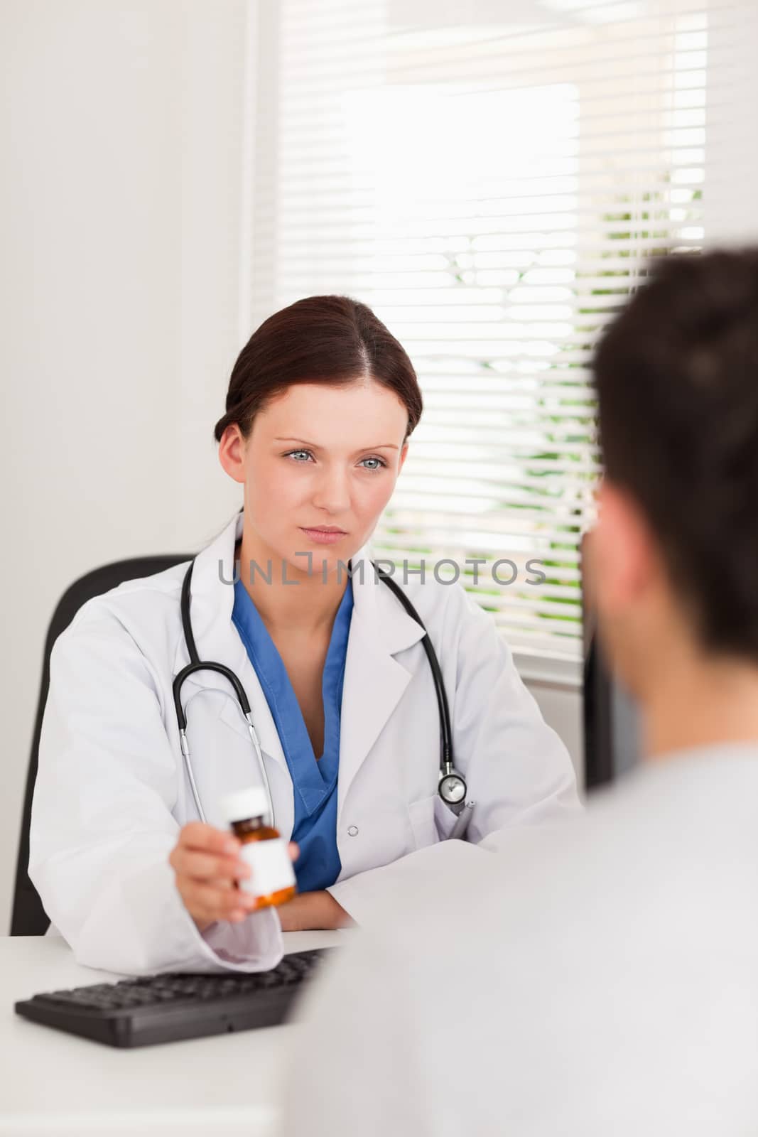 A female doctor is giving pills to a patient