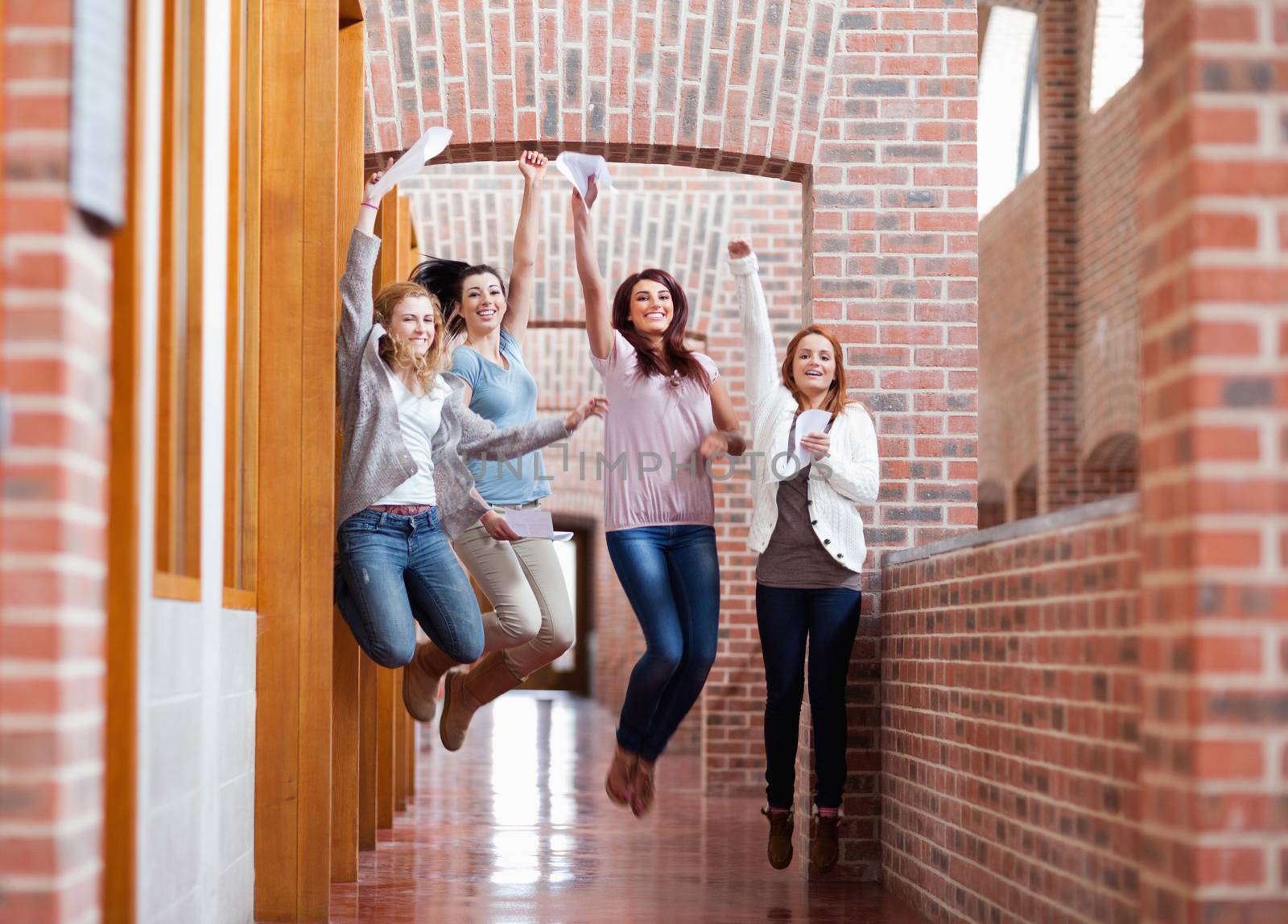 Students jumping with their results in a corridor