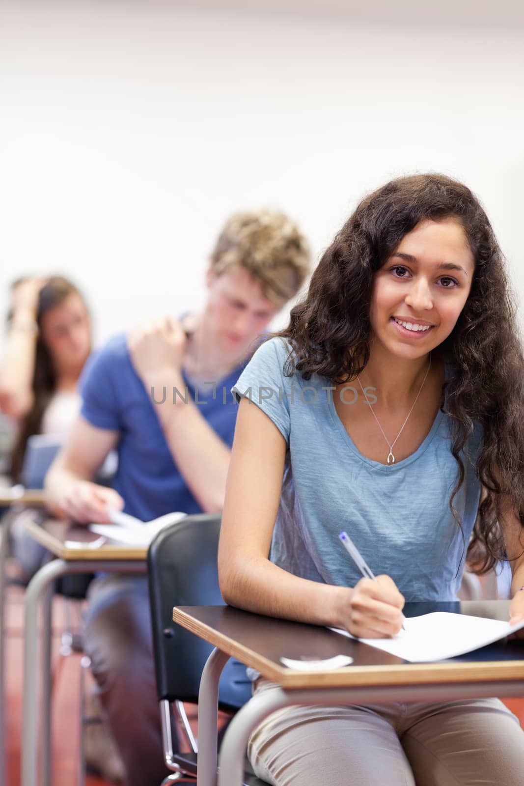 Portrait of smiling students working on an assignment in a classroom