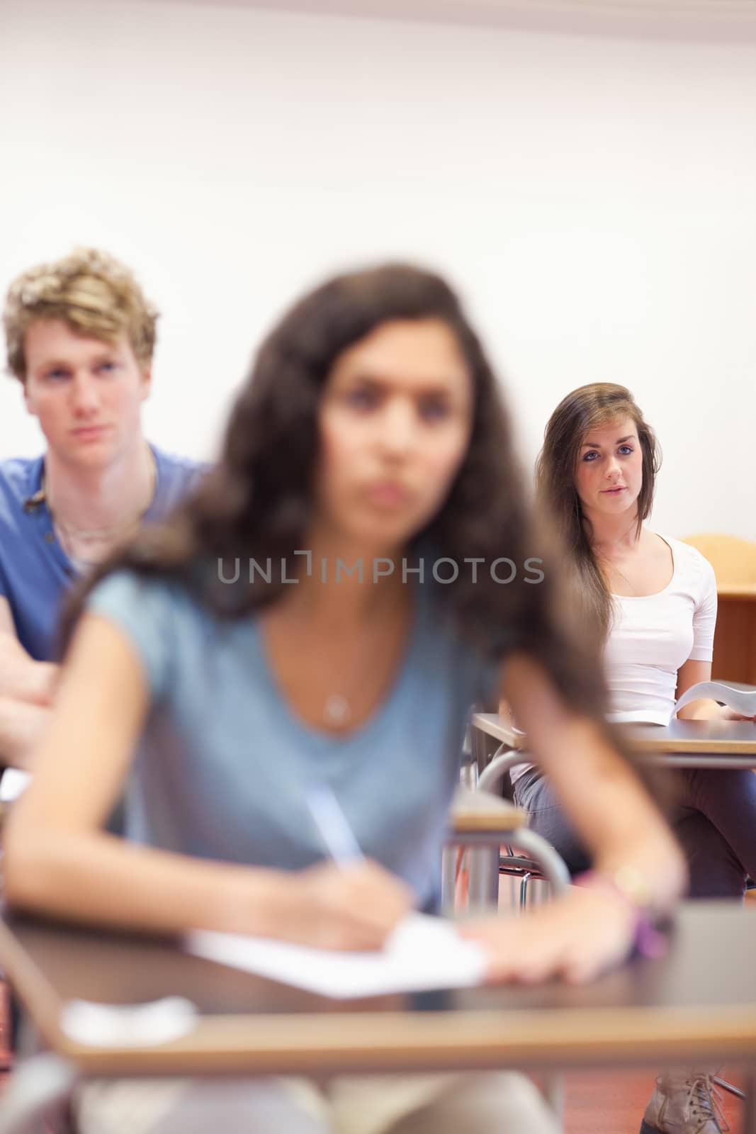 Portrait of serious students taking notes in a classroom