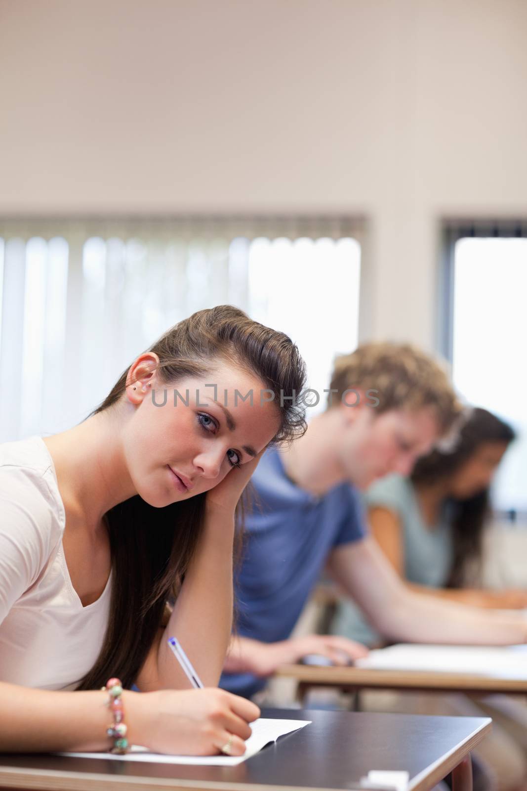 Portrait of a woman writing in a classroom