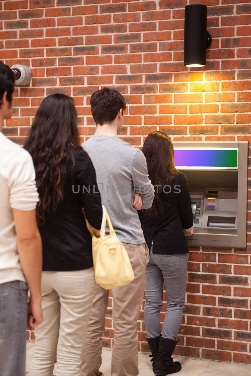 Portrait of people queuing to withdraw cash by Wavebreakmedia