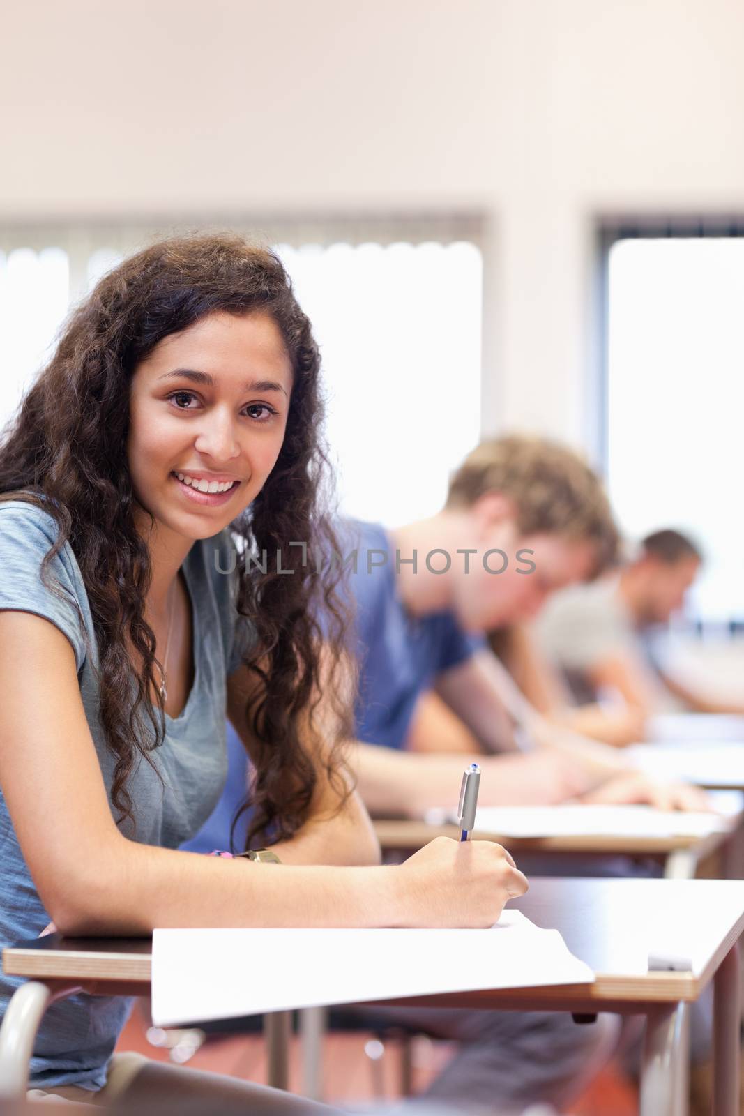 Portrait of a serious student writing in a classroom