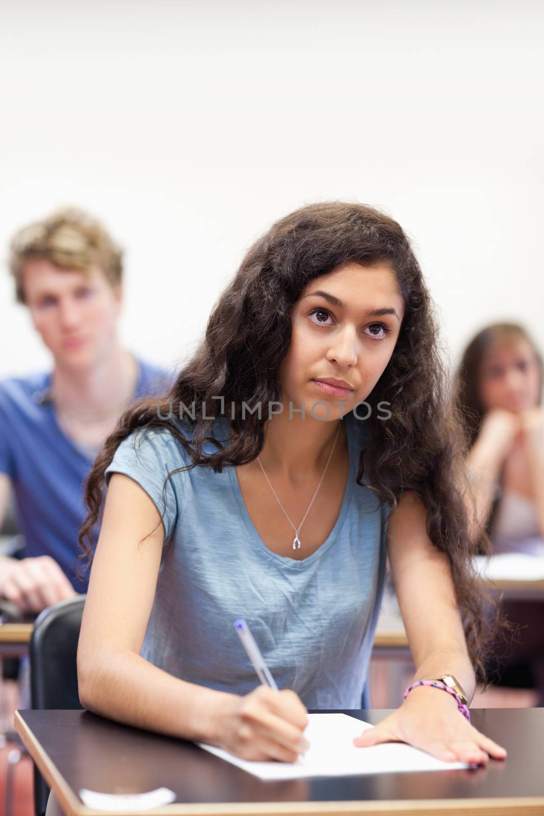 Portrait of a focused student taking notes in a classroom