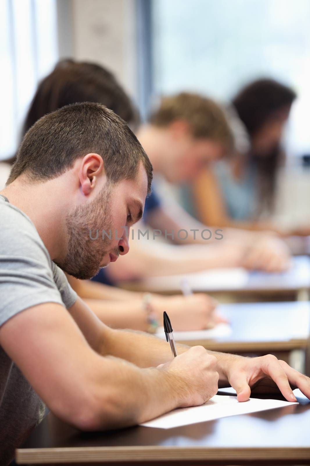 Portrait of a young man writing by Wavebreakmedia