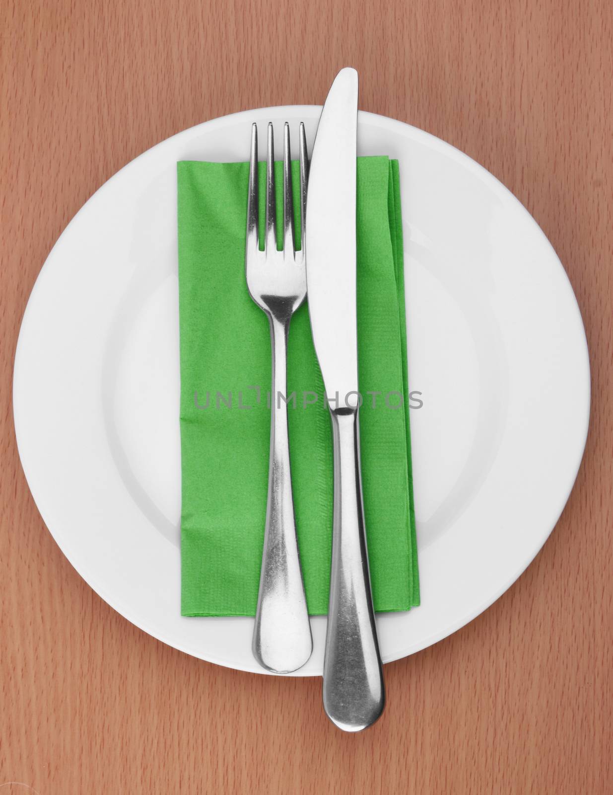 Fork and knife in a green cloth on white