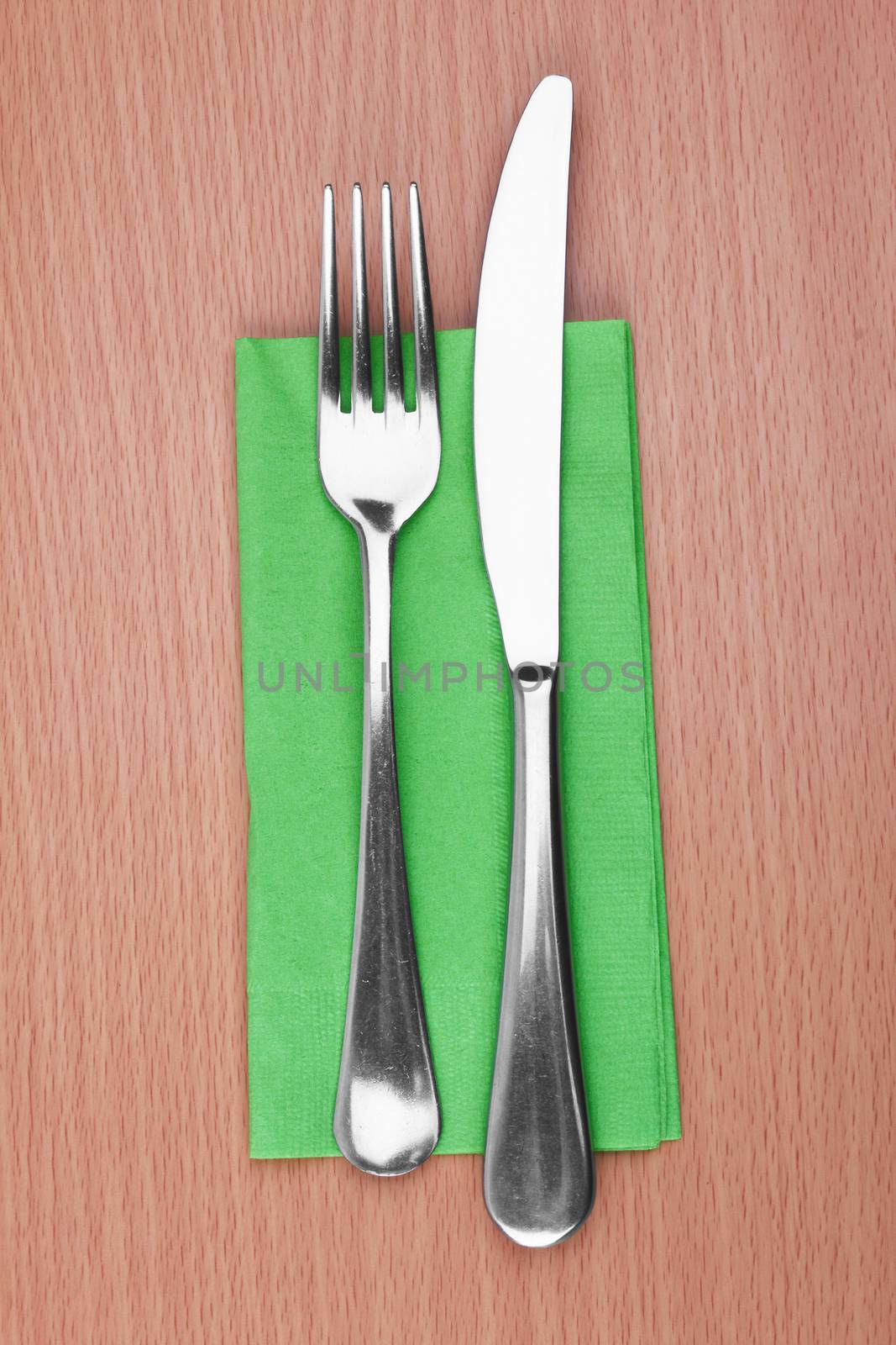 Fork and knife in a green cloth on white