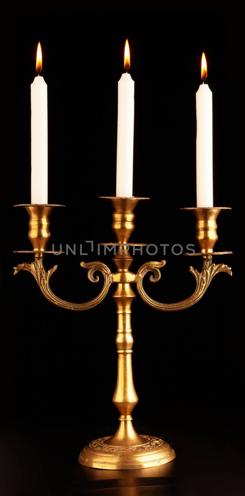 Old-fashioned baroque elegant candlestick on a black background 