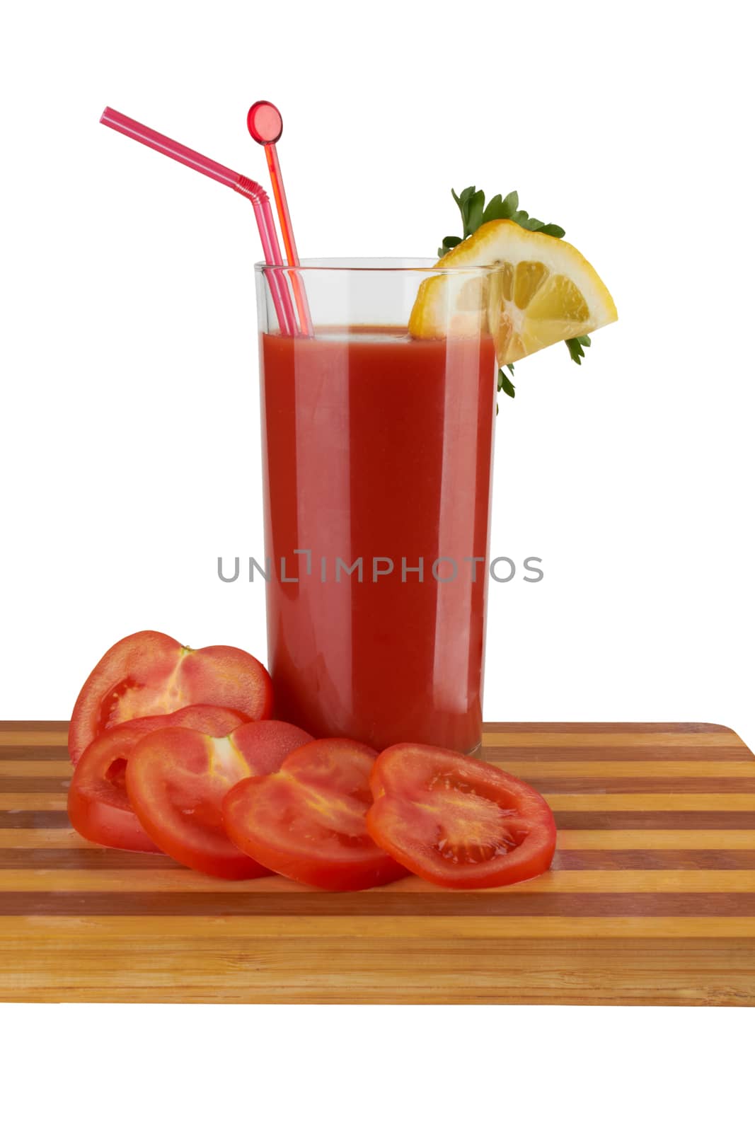 Fresh tomatoes and a glass full of tomato juice. 