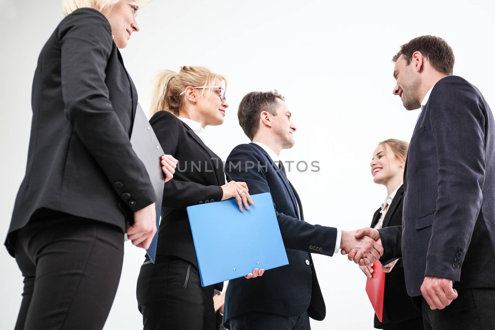 Business people shaking hands, finishing up a meeting, white background