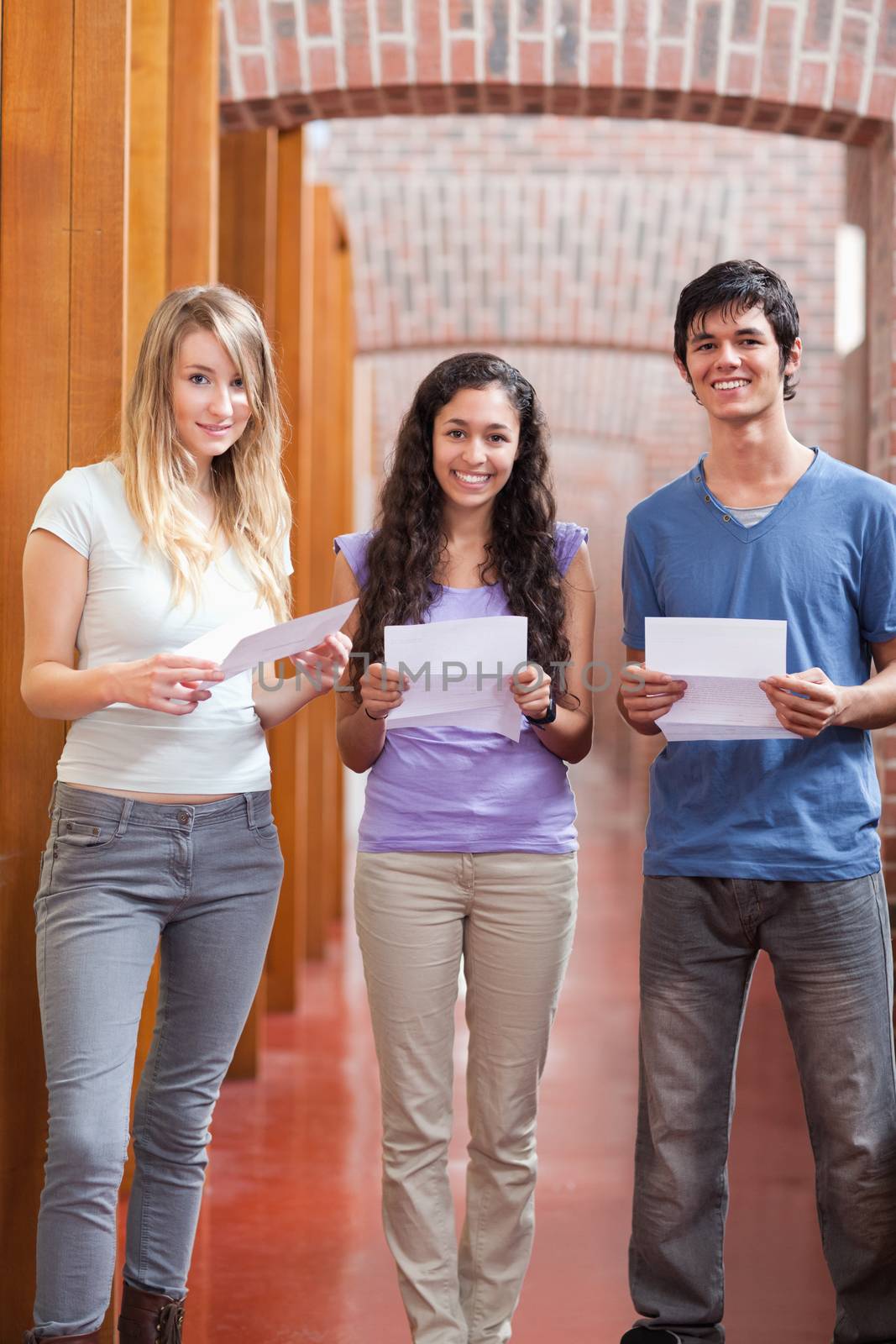 Portrait of smiling students holding a piece of paper by Wavebreakmedia