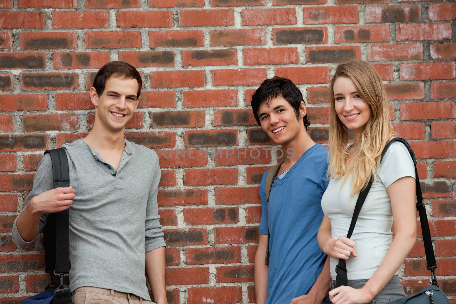 Smiling students posing outside a building