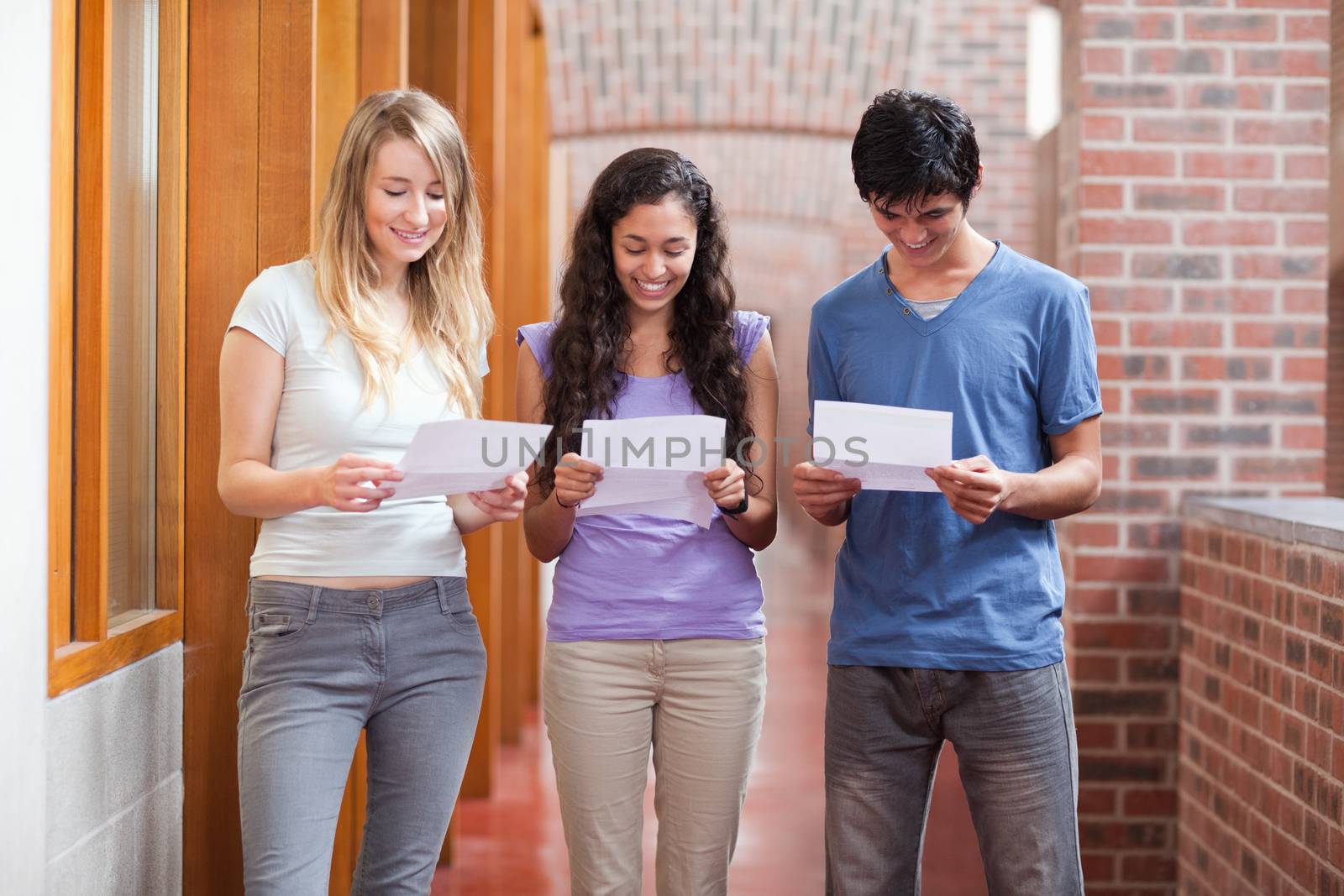 Students reading a piece of paper in a corridor