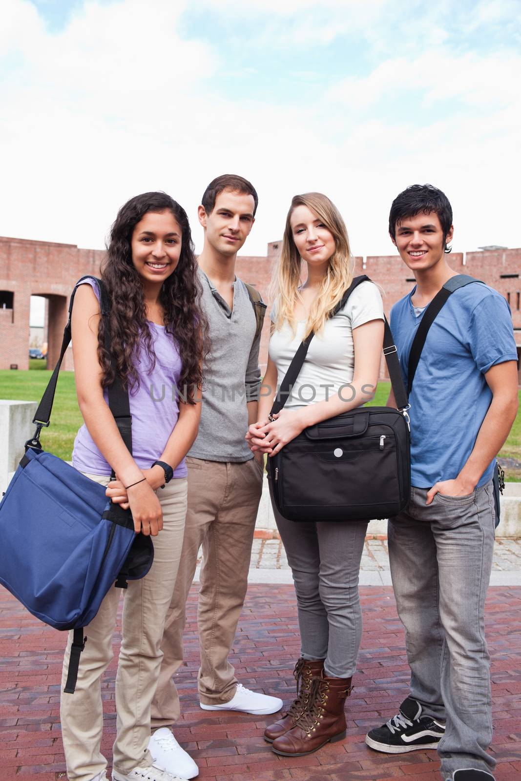Portrait of fellow students posing outside a building