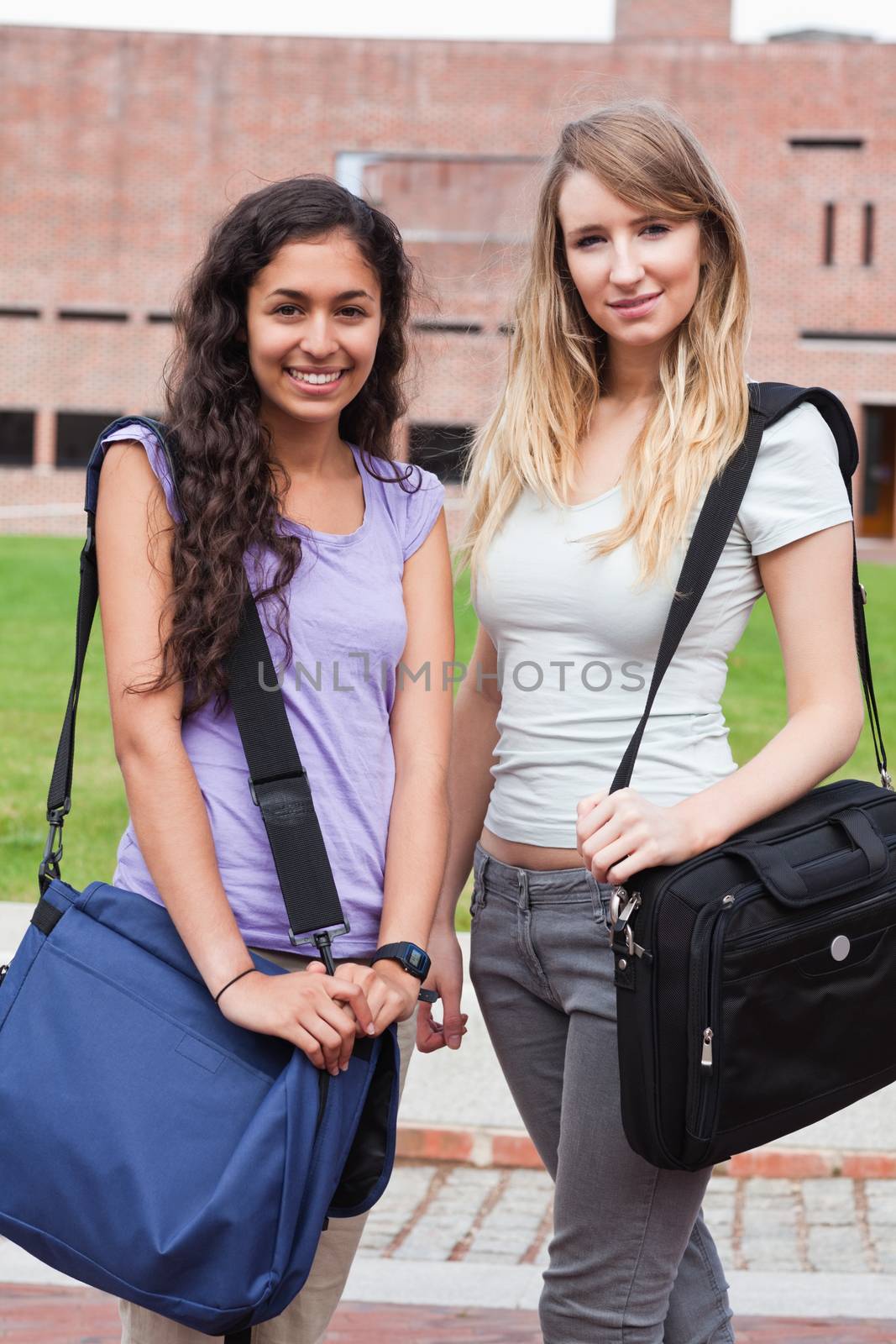 Portrait of smiling female students posing outside a building