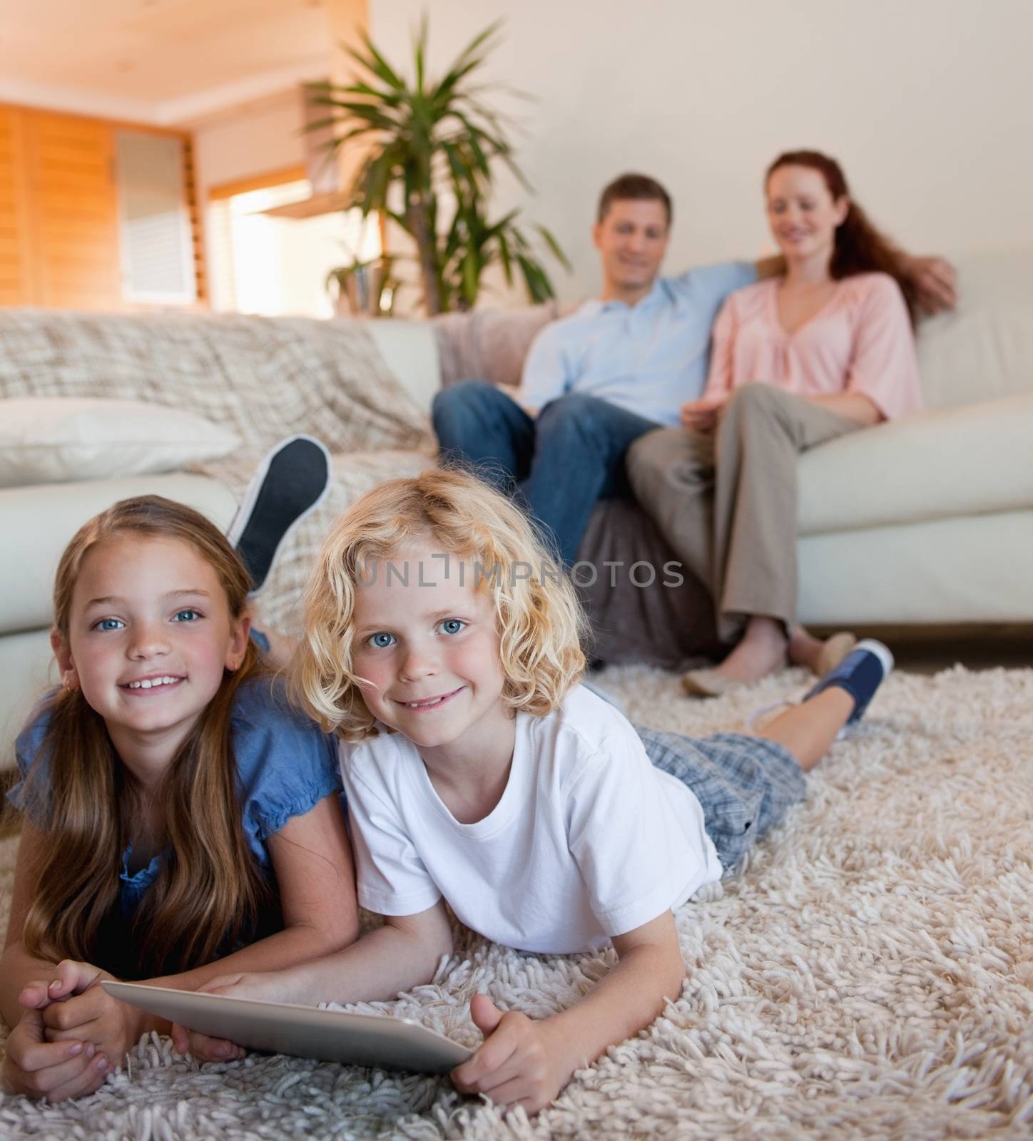 Children on the carpet using tablet by Wavebreakmedia