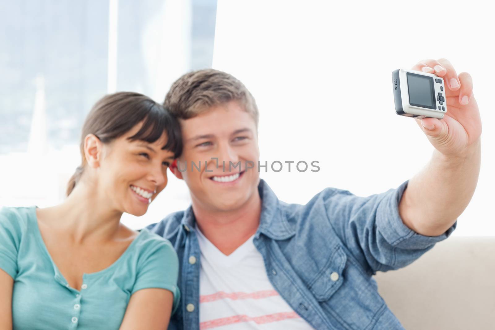 A couple pose for a photo together by smiling and pressing near each other.