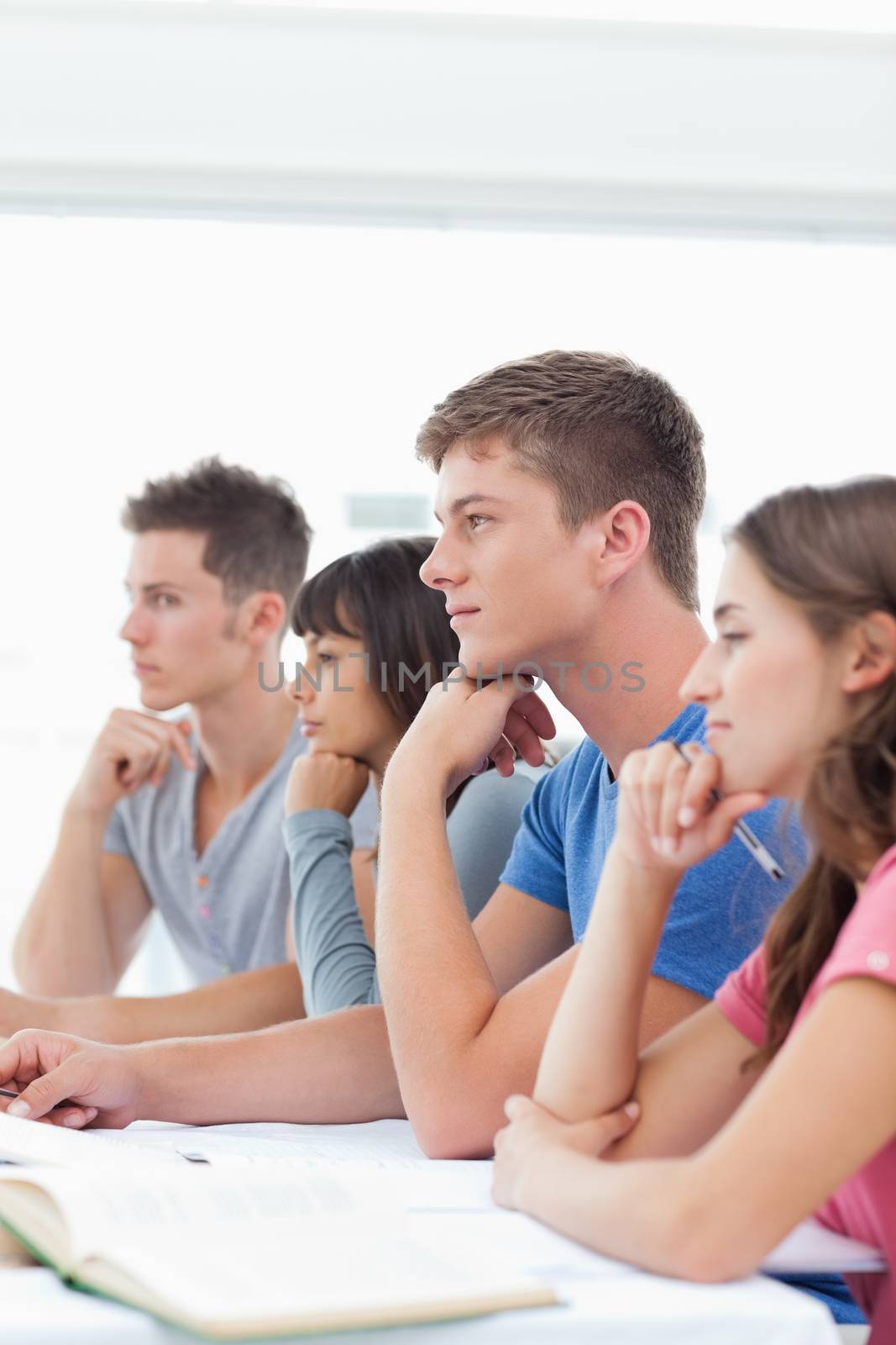 A group of students sitting in class listening by Wavebreakmedia