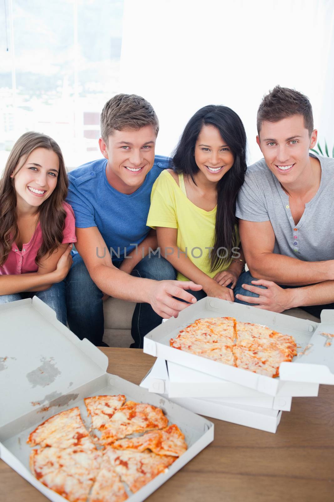 A smiling group of people about to eat as they look at the camera