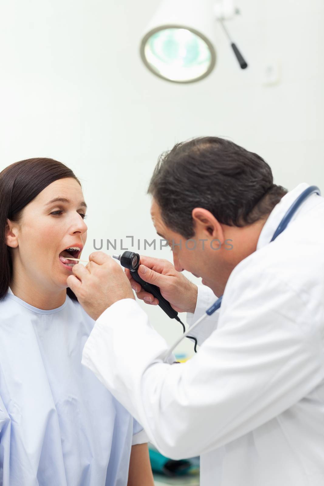 Doctor auscultating the mouth of his patient by Wavebreakmedia