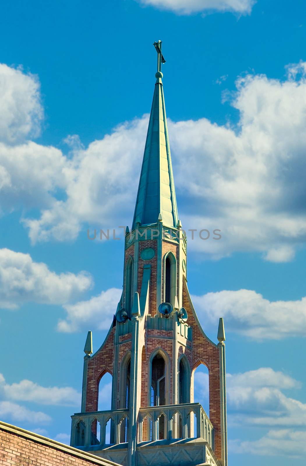 An old church steeple with bell tower against a blue sky
