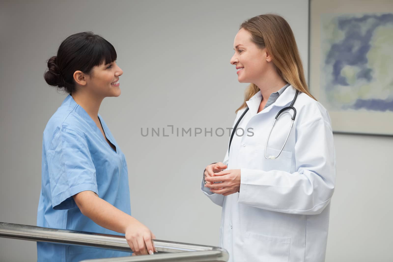 Nurse talking and smiling with female doctor by Wavebreakmedia