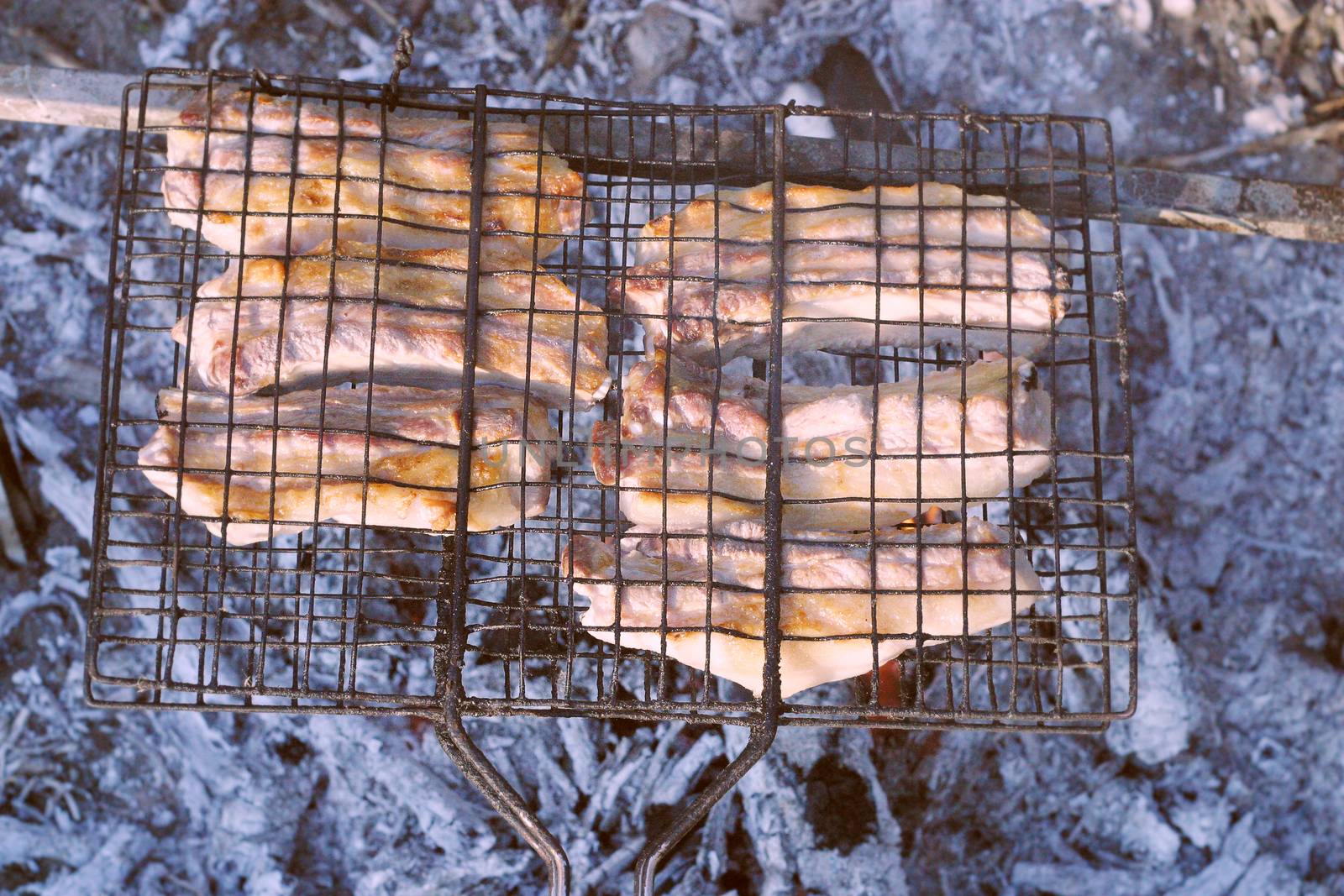 Barbeque from pork prepared outdoors on a hot summer day in a camp