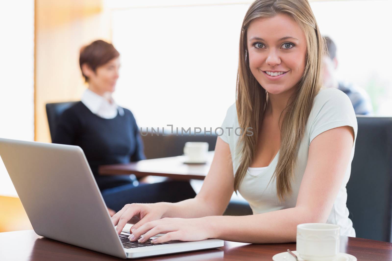 Student sitting at the coffee shop with laptop by Wavebreakmedia