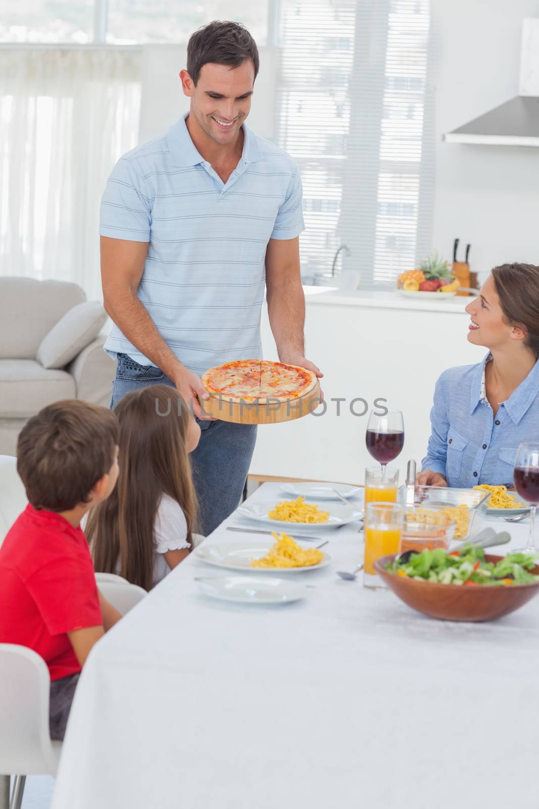 Man bringing a pizza to his family for the dinner