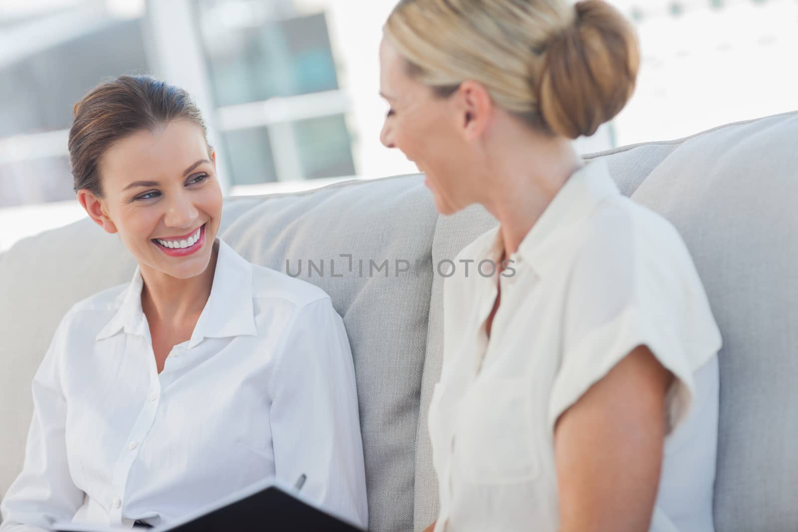Cheerful businesswomen talking and working together by Wavebreakmedia