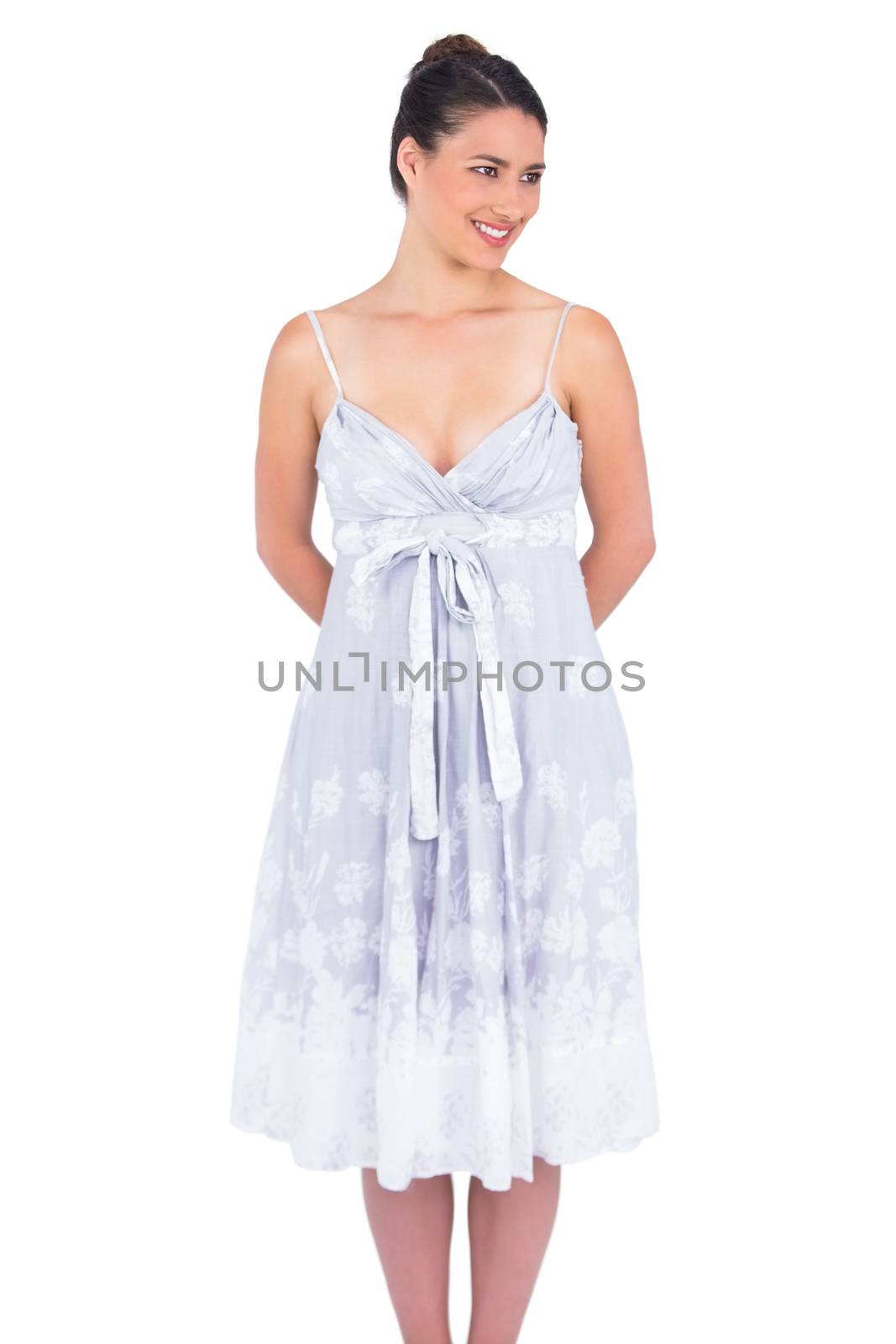 Cheerful seductive young model in summer dress posing on white background