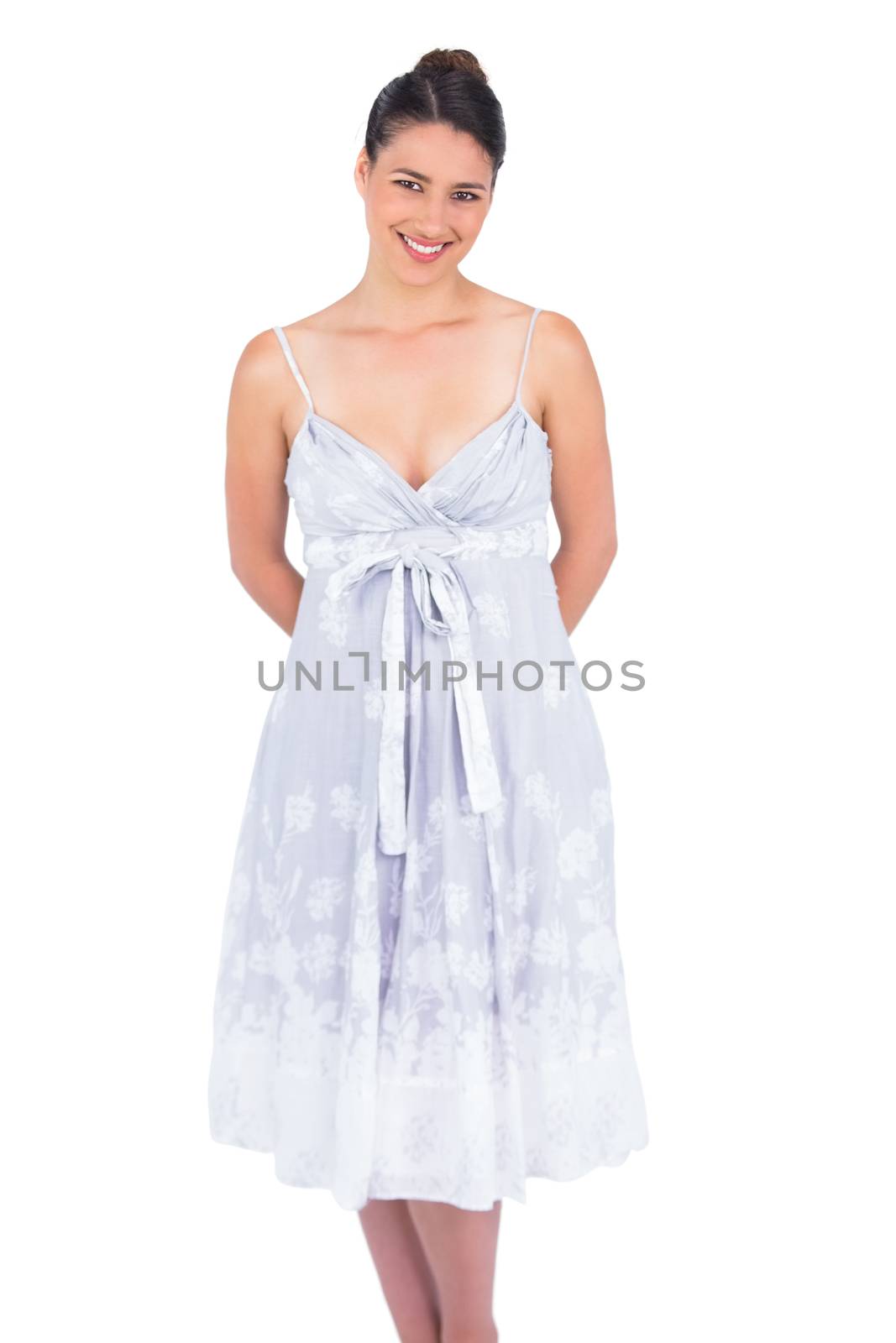 Smiling seductive young model in summer dress posing on white background