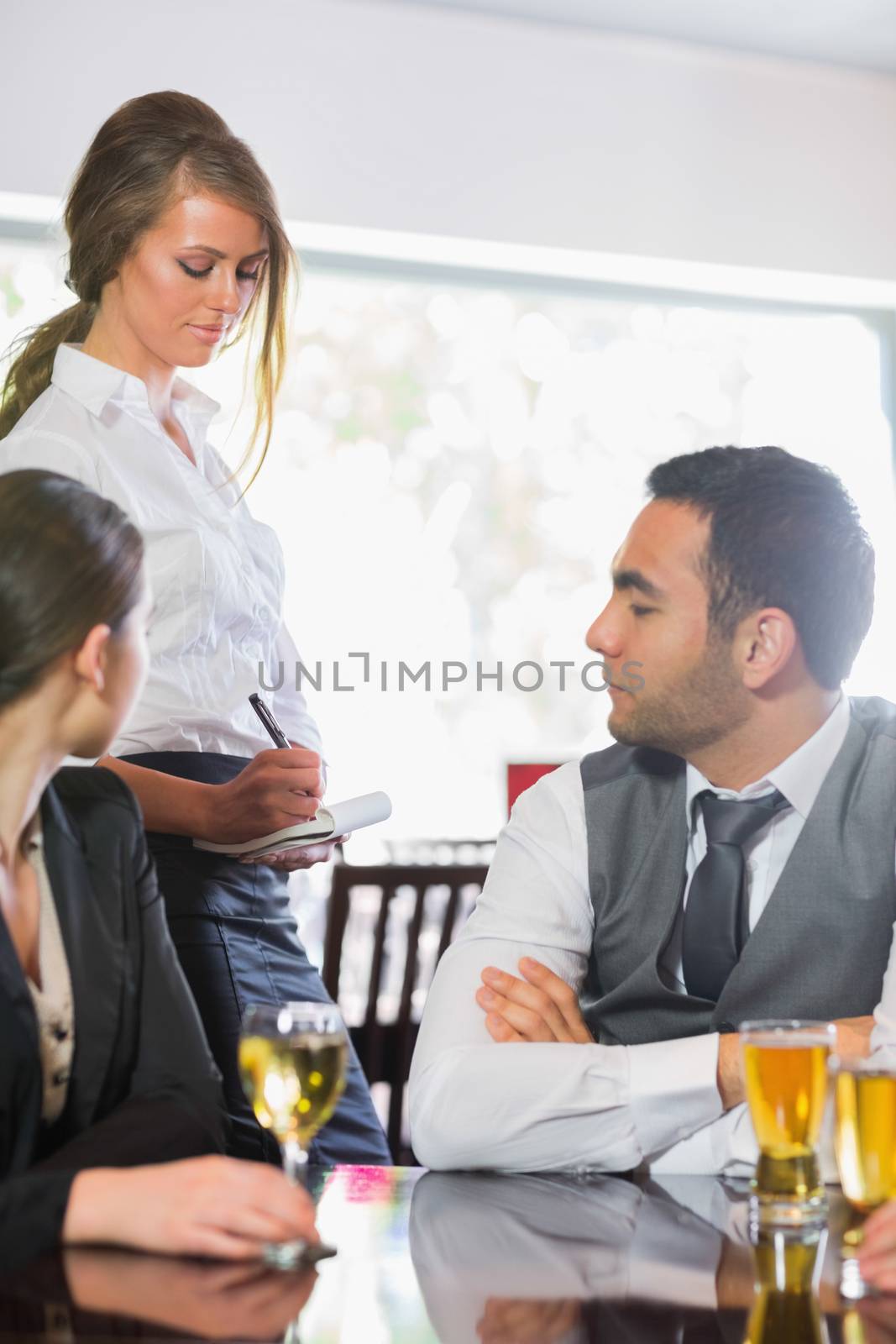 Business people ordering a dinner from waitress by Wavebreakmedia