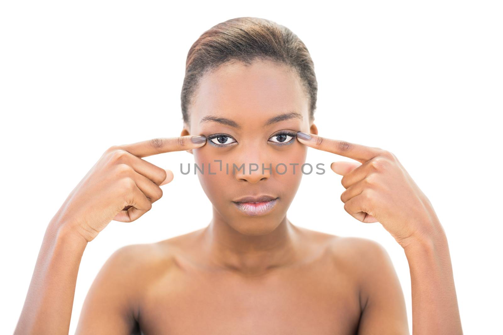 Natural beauty pointing at her eyes on white background