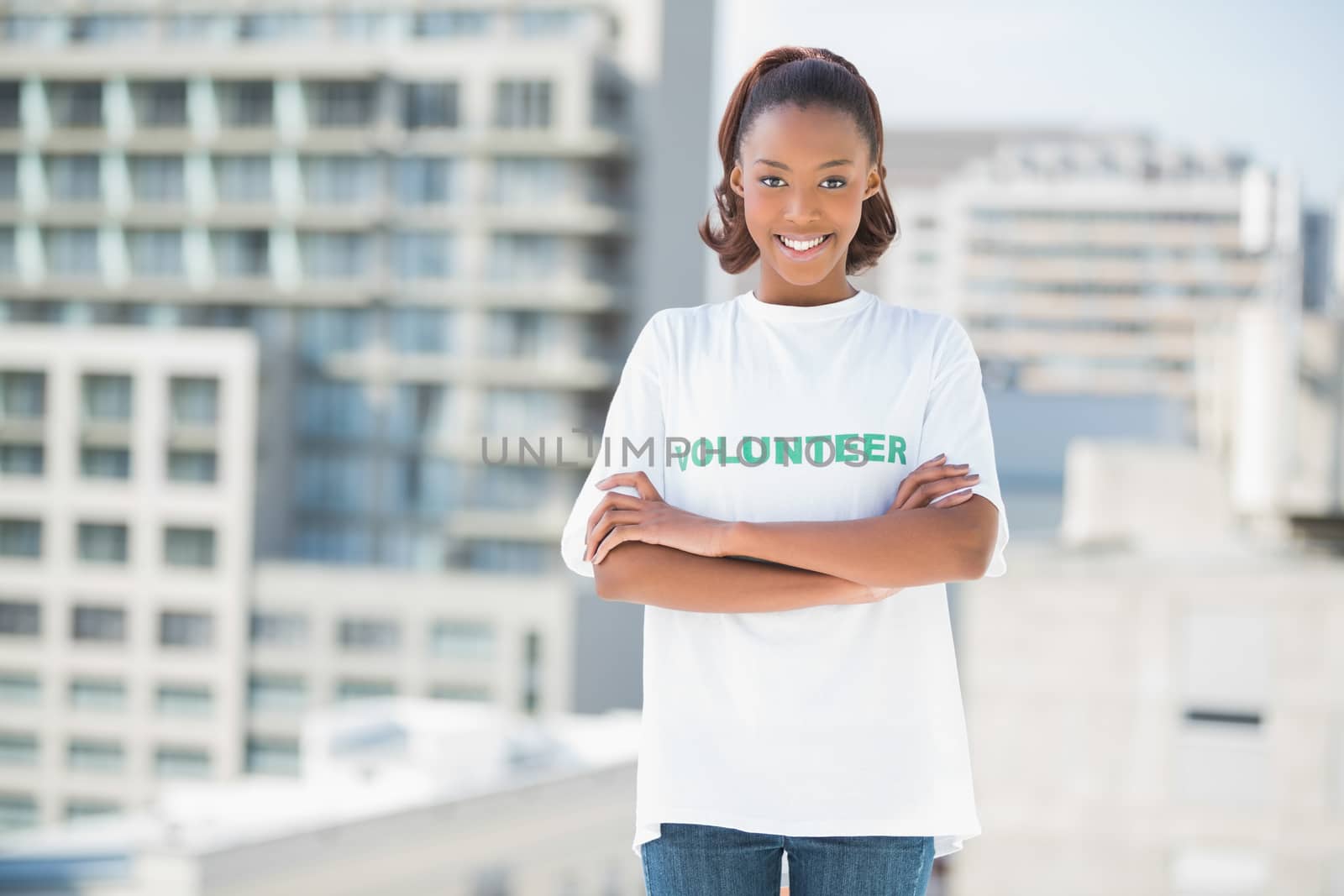 Woman standing with crossed arms outdoors on urban background