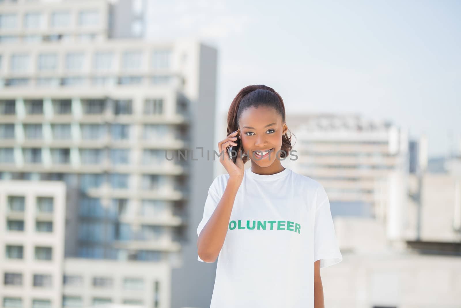 Cheerful altruist woman on the phone outdoors on urban background